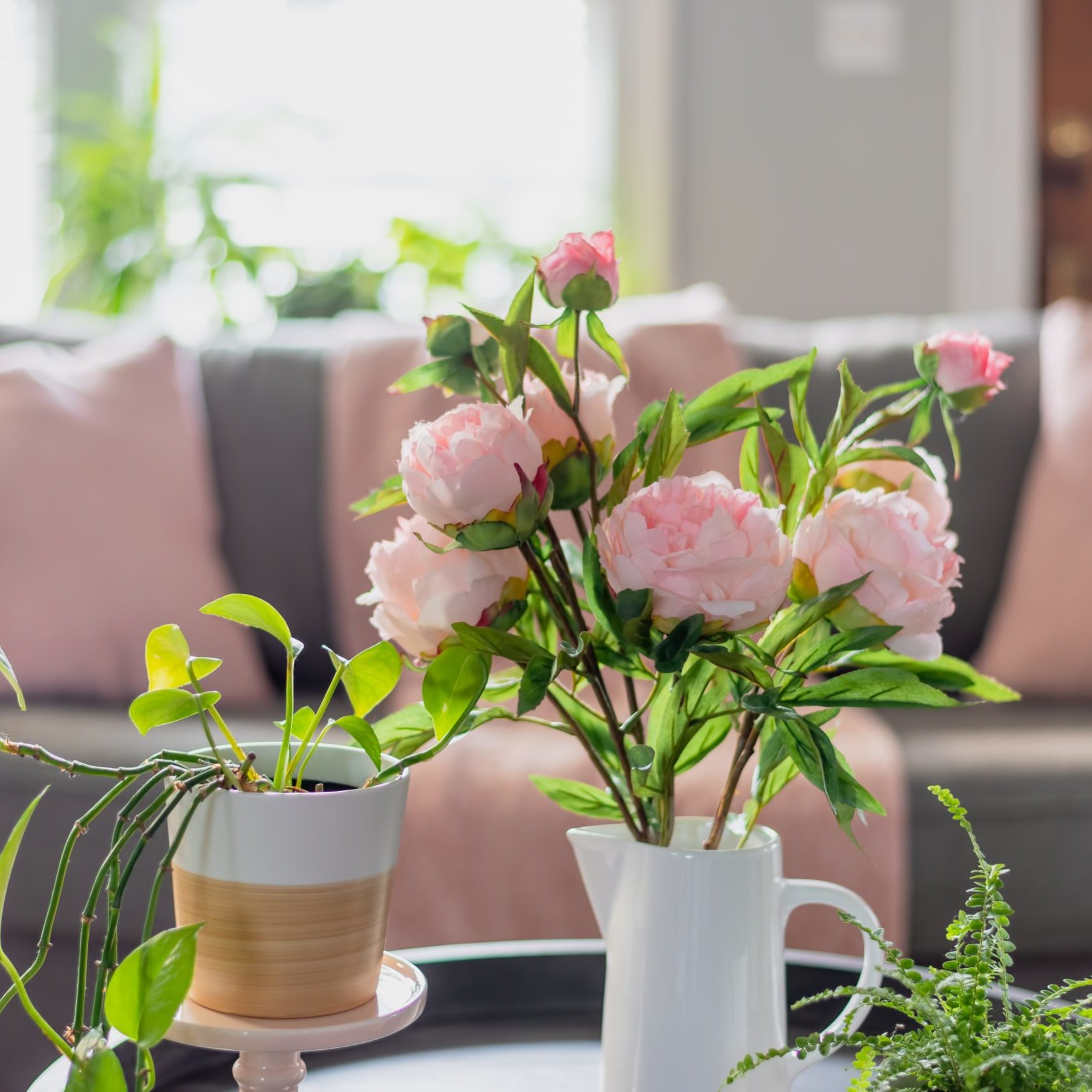 Pink peonies and potted plants brighten up the living room for Spring